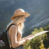 wanderlust-and-travel-concept-stylish-traveler-girl-in-hat-looking-at-map-exploring-woods--e1712714886988.jpg